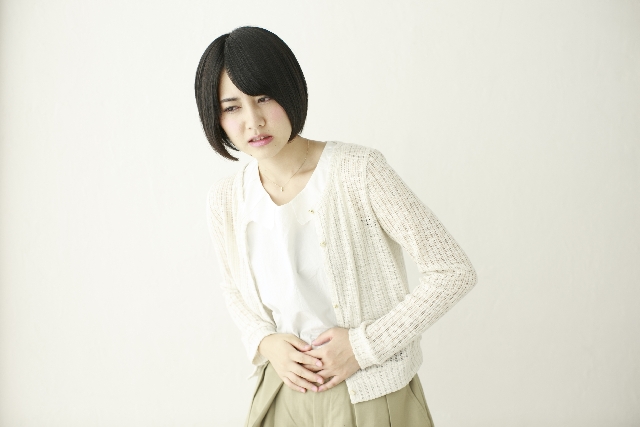 お腹を押さえる日本人女性