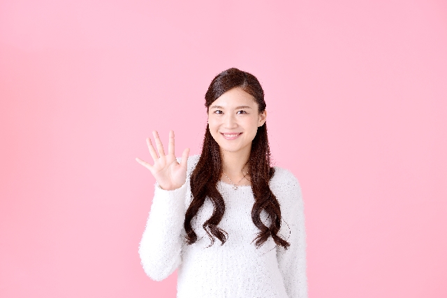 手で数字を作る女性